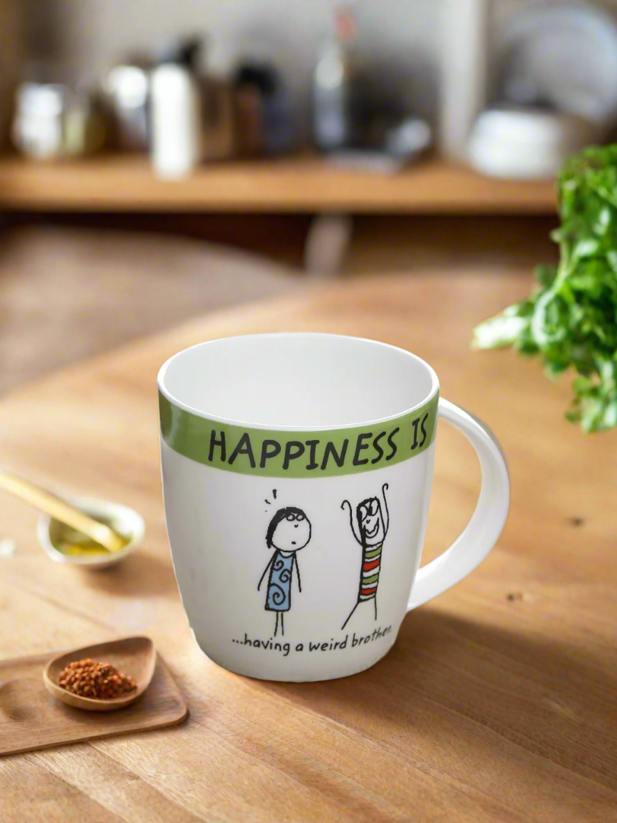 Mug with 'Happiness is... having a weird brother' text and illustrations on a table.