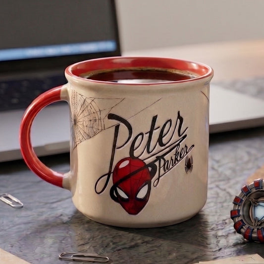 Mug with Spider-Man design on a desk with a laptop and newspaper