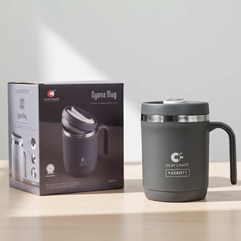 Black insulated mug with handle next to its packaging on a light surface.